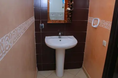 a bathroom with a white sink and a mirror at Bouznika H18 in Bouznika