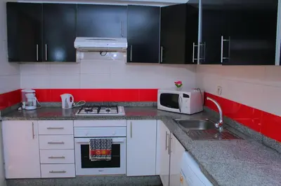 a kitchen with a sink and a microwave at Bouznika H18 in Bouznika