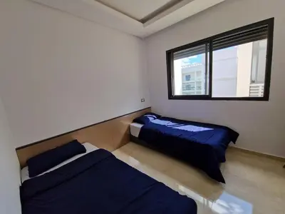 a bedroom with two beds and a window at Neo Home in Bouznika