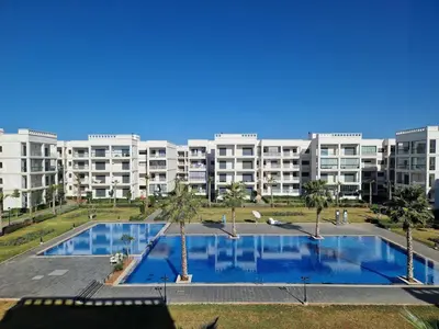 a large apartment building with a large swimming pool at Neo Home in Bouznika