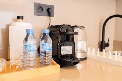 a coffee maker and two bottles of water on a counter at Les Princesses studio, self check-in, parking in Casablanca