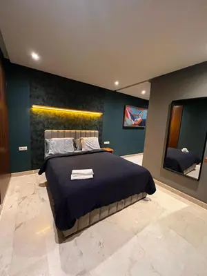 a bedroom with a large bed and two mirrors at Lux immo in Casablanca