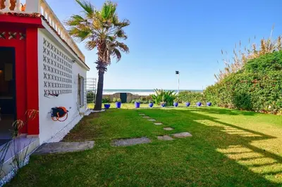 a yard with a palm tree next to a building at Grande villa luxueuse face à l'Océan in Temara