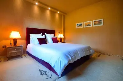 a bedroom with a large bed and two lamps at Grande villa luxueuse face à l'Océan in Temara