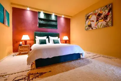 a bedroom with a bed and a painting on the wall at Grande villa luxueuse face à l'Océan in Temara