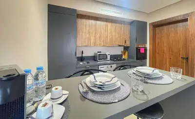 a kitchen with a table with plates and dishes on it at 12th Palm Living Modern Studio - Near Maarif in Casablanca