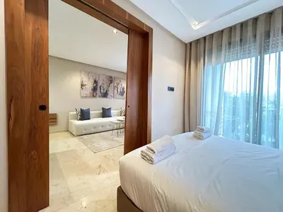 a bedroom with a bed and a living room at 12th Palm Living Modern Studio - Near Maarif in Casablanca
