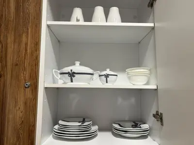 a cupboard with plates and utensils and bowls at 12th Palm Living Modern Studio - Near Maarif in Casablanca