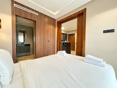 a bedroom with a large white bed with two white towels at 12th Palm Living Modern Studio - Near Maarif in Casablanca