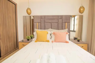 a bedroom with a large white bed with colorful pillows at AS29 studio luxueux au centre casablanca Tramway Parking free in Casablanca