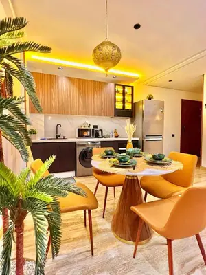 a kitchen with a table and yellow chairs and a kitchen at AS29 studio luxueux au centre casablanca Tramway Parking free in Casablanca
