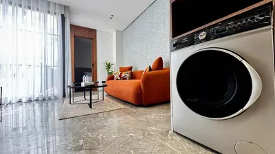 a living room with an orange couch and a washing machine at Pool in the Sky - By AppartAli in Casablanca