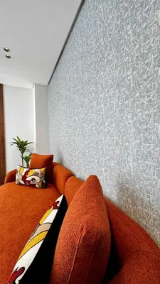 an orange couch in a room with a wall at Pool in the Sky - By AppartAli in Casablanca