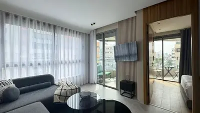 a living room with a blue couch and a television at The CFC View - By AppartAli in Casablanca
