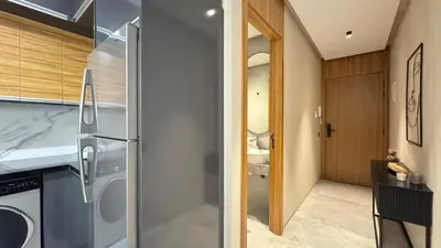a kitchen with a stainless steel refrigerator and wooden cabinets at The CFC View - By AppartAli in Casablanca