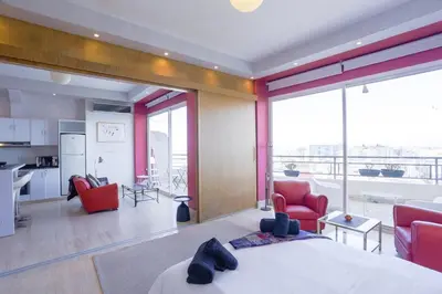 a bedroom with a bed and a kitchen and a living room at Villa Paquet - Quartier Art Déco in Casablanca