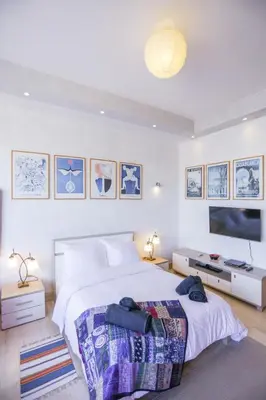 a bedroom with a large bed and a flat screen tv at Villa Paquet - Quartier Art Déco in Casablanca