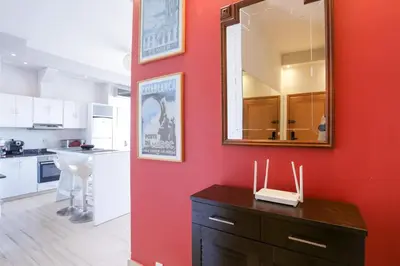 a red wall in a kitchen with a mirror at Villa Paquet - Quartier Art Déco in Casablanca
