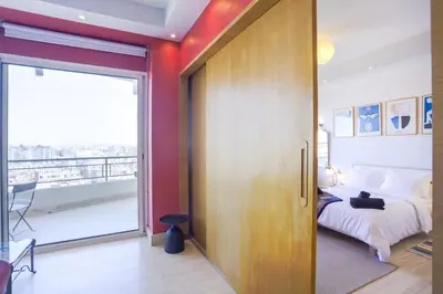 a bedroom with a bed and a large sliding door at Villa Paquet - Quartier Art Déco in Casablanca