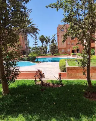 a swimming pool in the middle of a park at Ricoflores Mansouria in Mansouria