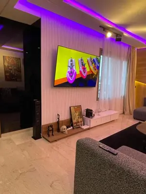a living room with a tv and purple lighting at Luxoria 2 californie in Casablanca