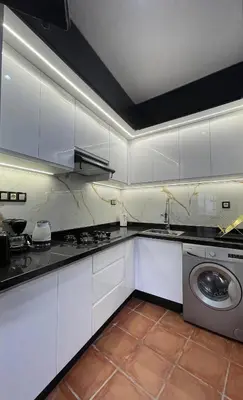 a kitchen with white cabinets and a washing machine at Apartment in a beachfront complex in Casablanca