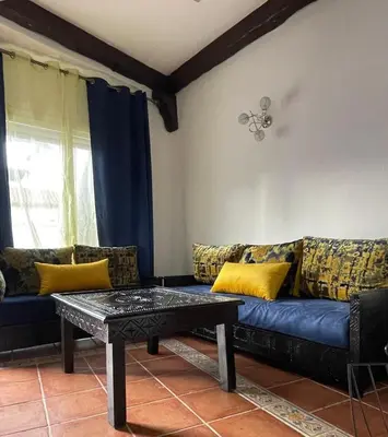 a living room with a blue couch with yellow pillows at Apartment in a beachfront complex in Casablanca