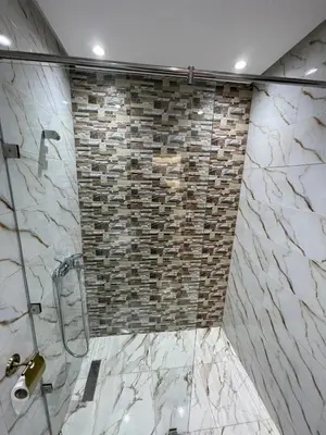 a bathroom with a shower with a stone wall at Apartment in a beachfront complex in Casablanca