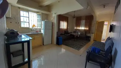 a kitchen and living room with a white refrigerator at Maison équipée prêt de la plage in Temara