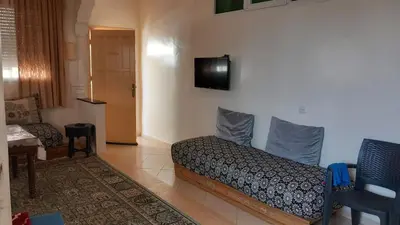 a room with a bed and a tv on the wall at Maison équipée prêt de la plage in Temara