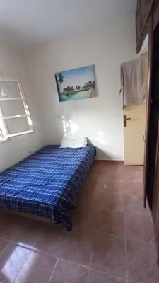 a small bedroom with a blue bed in a room at Maison équipée prêt de la plage in Temara