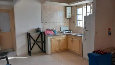 a kitchen with a counter and a refrigerator at Maison équipée prêt de la plage in Temara