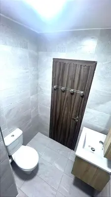a bathroom with a toilet and a wooden door at BOUZNIKA PLAGe in Bouznika