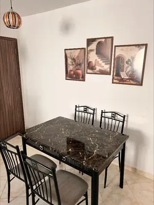 a dining room table with four chairs and a marble top at BOUZNIKA PLAGe in Bouznika