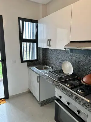 a small kitchen with a stove and a sink at Appartement à Témara - Élégance et confort in Temara