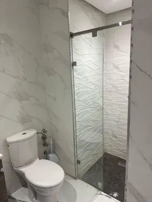 a bathroom with a toilet and a glass shower at Appartement à Témara - Élégance et confort in Temara