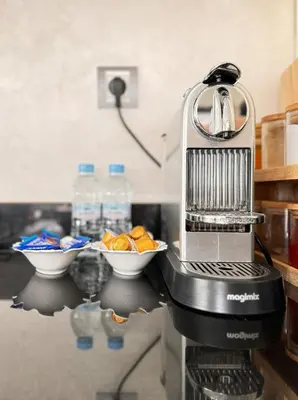 a food processor on a counter with a bowl of oranges at Luxury Beachview Apartment La siesta beach resort in Mohammedia