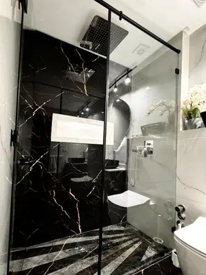 a bathroom with a glass shower with a toilet at Luxury Beachview Apartment La siesta beach resort in Mohammedia