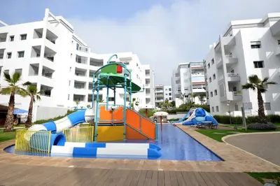 a playground in front of a apartment complex at Luxury Beachview Apartment La siesta beach resort in Mohammedia