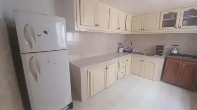 a kitchen with white cabinets and a white refrigerator at Le Refuge in Temara