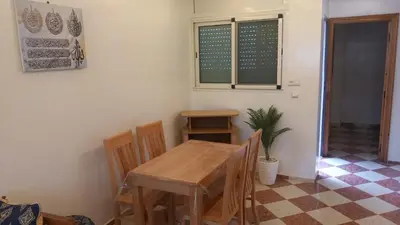 a dining room with a wooden table and chairs at Le Refuge in Temara