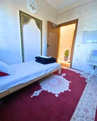 a bedroom with a bed with a mirror and a red rug at Appartement Calme à Mohammadia - Séjour Agréable in Mohammedia