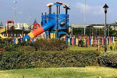 a playground with a slide in a park at appartement ola blanca 2 in Dar Hamida