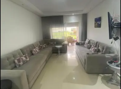 a living room with a long couch in a room at appartement ola blanca 2 in Dar Hamida