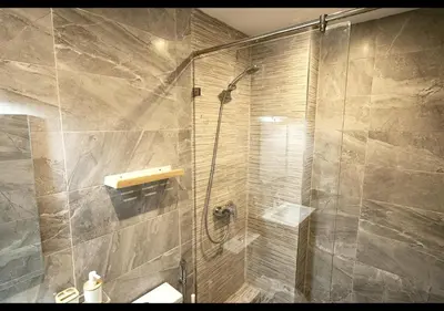 a shower with a glass door in a bathroom at Havre de paix au bord de mer in Pont Blondin
