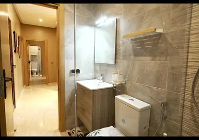 a bathroom with a toilet and a sink and a shower at Havre de paix au bord de mer in Pont Blondin