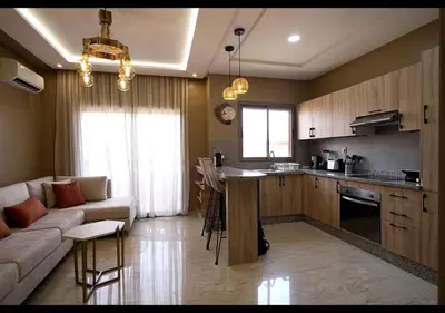 a kitchen and living room with a couch and a table at Havre de paix au bord de mer in Pont Blondin