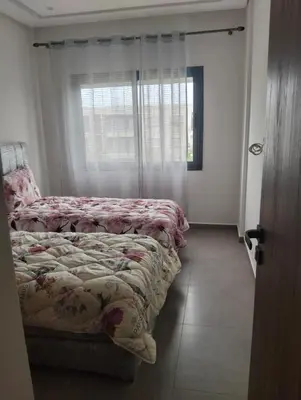 a bedroom with two beds and a window at Appartement avec piscine El mansoria Mohammedia in Mansouria