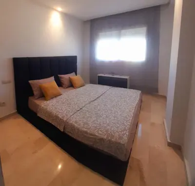 a bedroom with a bed with orange pillows and a window at Appartamento Narjis in Casablanca