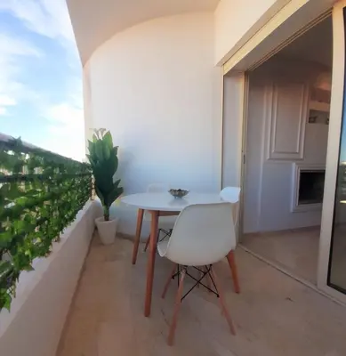 a white table and a white chair on a balcony at Appartamento Narjis in Casablanca